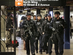 Police officers patrol in the passageway connecting New York City's Port Authority bus terminal and the Times Square subway station on Tuesday, Dec. 12, 2017, near the site of Monday's explosion. Commuters returning to New York City's subway system on Tuesday were met with heightened security a day after a would-be suicide bomber's rush-hour blast failed to cause the bloodshed he intended.