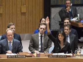 In this Monday, Dec. 18, 2017 photo, U.S. Ambassador to the United Nations Nikki Haley, right, votes against a resolution concerning Jerusalem's status at U.N. headquarters.  The United States on Monday vetoed a resolution supported by the 14 other U.N. Security Council members that would have required President Donald Trump to rescind his declaration of Jerusalem as the capital of Israel, a vote that showed the depth of global opposition to the U.S. move.