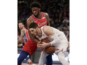 Philadelphia 76ers' Joel Embiid, top, and New York Knicks' Enes Kanter fight for a loose ball during the first half of the NBA basketball game, Monday, Dec. 25, 2017, in New York.