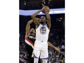 Golden State Warriors' Kevin Durant (35) shoots as Portland Trail Blazers' CJ McCollum defends during the first half of an NBA basketball game Monday, Dec. 11, 2017, in Oakland, Calif.