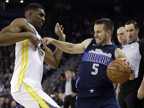 Dallas Mavericks' J.J. Barea (5) is defended by Golden State Warriors' Kevon Looney during the first half of an NBA basketball game Thursday, Dec. 14, 2017, in Oakland, Calif.