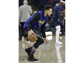 Golden State Warriors guard Stephen Curry practices warms up for the team's NBA basketball game against the Denver Nuggets in Oakland, Calif., Saturday, Dec. 23, 2017.