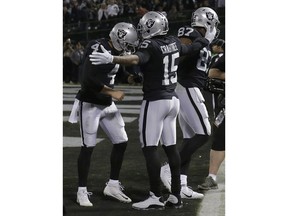 Oakland Raiders quarterback Derek Carr (4) and wide receiver Michael Crabtree (15) celebrate after connecting on a touchdown during the second half of an NFL football game against the Dallas Cowboys in Oakland, Calif., Sunday, Dec. 17, 2017.