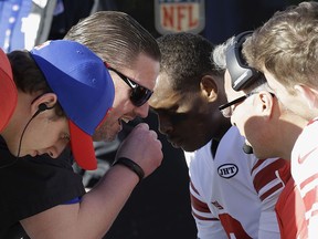 New York Giants head coach Ben McAdoo, second from left, talks with quarterback Geno Smith, center, Eli Manning, right, and Davis Webb, left, during the first half of an NFL football game against the Oakland Raiders in Oakland, Calif., Sunday, Dec. 3, 2017.