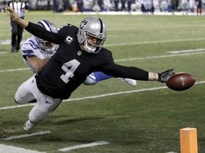 Oakland Raiders quarterback Derek Carr (4) fumbles the ball into the end zone in front of Dallas Cowboys strong safety Jeff Heath (38) during the second half of an NFL football game in Oakland, Calif., Sunday, Dec. 17, 2017. The play was ruled a touchback and the Cowboys got possession. The Cowboys won 20-17.