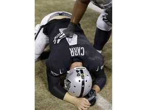 Oakland Raiders quarterback Derek Carr (4) puts his head down on the field after losing a fumble on a touchback against the Dallas Cowboys during the second half of an NFL football game in Oakland, Calif., Sunday, Dec. 17, 2017. The Cowboys won 20-17.