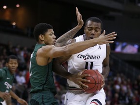 Cincinnati forward Gary Clark (11) is pressured by Cleveland State forward Anthony Wright during the first half of an NCAA college basketball game Thursday, Dec. 21, 2017, in Highland Heights, Ky.