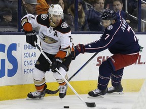 Anaheim Ducks' Andrew Cogliano, left, looks for an open pass as Columbus Blue Jackets' Jack Johnson defends during the first period of an NHL hockey game Friday, Dec. 1, 2017, in Columbus, Ohio.