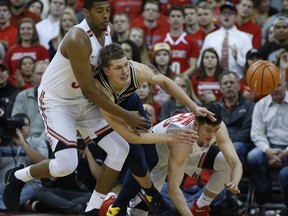 Michigan's Moritz Wagner, center, passes the ball as Ohio State's Kaleb Wesson, left, and Kyle Young defend during the first half of an NCAA college basketball game Monday, Dec. 4, 2017, in Columbus, Ohio.
