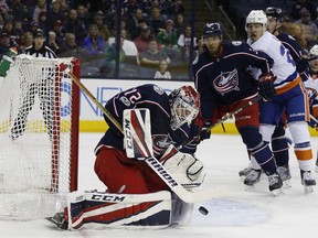 Columbus Blue Jackets' Sergei Bobrovsky, left, of Russia, makes a save as teammate Seth Jones, center, and New York Islanders' Anders Lee look for the rebound during the first period of an NHL hockey game Thursday, Dec. 14, 2017, in Columbus, Ohio.