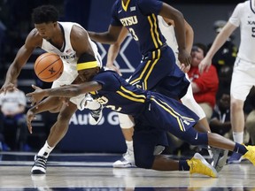 East Tennessee State's Jalan McCloud, right, and Xavier's Quentin Goodin, left, battle for a loose ball in the first half of an NCAA college basketball game, Saturday, Dec. 16, 2017, in Cincinnati.