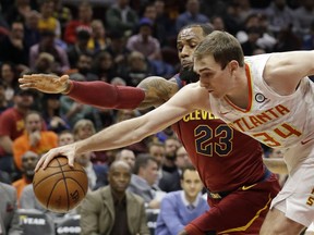 Atlanta Hawks' Tyler Cavanaugh (34) and Cleveland Cavaliers' LeBron James (23) battle for a loose ball in the first half of an NBA basketball game, Tuesday, Dec. 12, 2017, in Cleveland.
