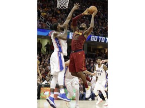 Cleveland Cavaliers' LeBron James, right, drives to the basket Philadelphia 76ers' Amir Johnson during the second half of an NBA basketball game Saturday, Dec. 9, 2017, in Cleveland. The Cavaliers won 105-98.