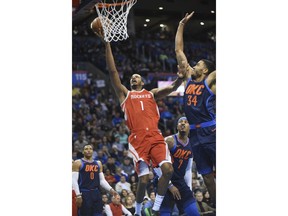 Houston Rockets' Trevor Ariza (1) shoots the ball around Oklahoma City Thunders' Josh Heustis (34) in the first quarter of an NBA basketball game in Oklahoma City, Monday, Dec. 25, 2017.