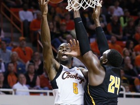 Oklahoma State guard Tavarius Shine (5) shoots as Wichita State center Shaquille Morris (24) defends in the first half of an NCAA college basketball game in Stillwater, Okla., Saturday, Dec. 9, 2017.