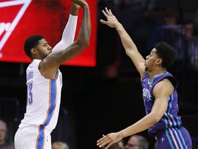 Oklahoma City Thunder forward Paul George (13) shoots over Charlotte Hornets guard Jeremy Lamb, right, in the first quarter of an NBA basketball game in Oklahoma City, Monday, Dec. 11, 2017.