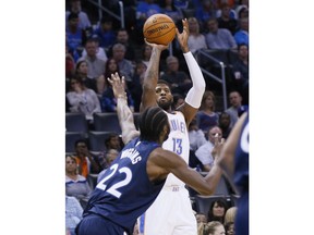 Oklahoma City Thunder forward Paul George (13) shoots over Minnesota Timberwolves forward Andrew Wiggins (22) during the first quarter of an NBA basketball game in Oklahoma City, Friday, Dec. 1, 2017.