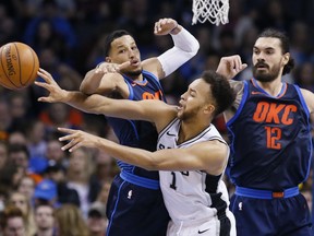 San Antonio Spurs forward Kyle Anderson (1) passes the ball in front of Oklahoma City Thunder guard Andre Roberson, left, and center Steven Adams (12) during the second quarter of an NBA basketball game in Oklahoma City, Sunday, Dec. 3, 2017.