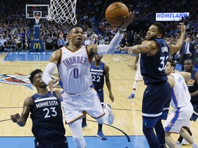 Oklahoma City Thunder guard Russell Westbrook (0) shoots between Minnesota Timberwolves guard Jimmy Butler (23) and center Karl-Anthony Towns during the second quarter of an NBA basketball game in Oklahoma City, Friday, Dec. 1, 2017.