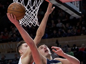 Denver Nuggets center Nikola Jokic, right, shoots over Portland Trail Blazers center Zach Collins during the first half of an NBA basketball game in Portland, Ore., Friday, Dec. 22, 2017.