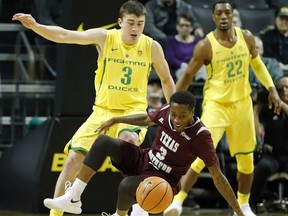 Texas Southern guard Demontrae Jefferson loses his footing but retains control of the ball as he is guarded by Oregon guard Payton Pritchard during the first half of an NCAA college basketball game in Eugene, Ore., Monday, Dec. 11, 2017. Oregon won, 74-68.