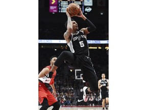 San Antonio Spurs guard Dejounte Murray drives to the basket past Portland Trail Blazers guard Evan Turner during the first half of an NBA basketball game in Portland, Ore., Wednesday, Dec. 20, 2017.