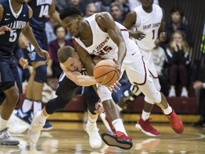 Saint Joseph's James Demery, right, gets fouled by Villanova's Donte DiVincenzo, left, as they go for the all during the first half of an NCAA college basketball game, Saturday, Dec. 2, 2017, in Philadelphia.