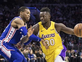 Los Angeles Lakers Julius Randle, right, drives to the basket against Philadelphia 76ers Richaun Holmes, left, during the first half of an NBA basketball game, Thursday, Dec. 7, 2017, in Philadelphia.