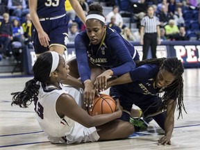 Pennsylvania's Michelle Nwokedi, left, tries to keep control of the ball as Notre Dame's Kristina Nelson, center, and Lili Thompson, right, try to strip it away during the first half of an NCAA college basketball game, Saturday, Dec. 9, 2017, in Philadelphia.