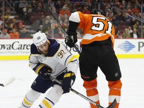 Buffalo Sabres' Ryan O'Reilly, left, goes around Philadelphia Flyers' Valtteri Filppula, right, of Finland, to get the puck after the face-off during the first period of an NHL hockey game, Thursday, Dec. 14, 2017, in Philadelphia.