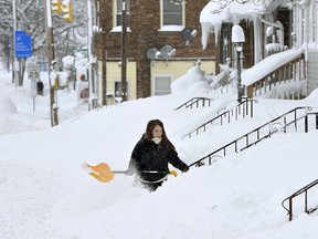 Rochelle Carlotti, 28, shovels steps near her home after a record snowfall on Tuesday, Dec. 26, 2017, in Erie, Pa. The National Weather Service office in Cleveland says Monday's storm brought 34 inches of snow, an all-time daily snowfall record for Erie.