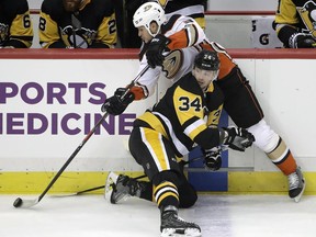 Anaheim Ducks' Kevin Bieksa (3) gets off a pass after colliding with Pittsburgh Penguins' Tom Kuhnhackl (34) during the first period of an NHL hockey game in Pittsburgh, Saturday, Dec. 23, 2017.