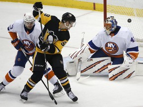 Pittsburgh Penguins' Jake Guentzel (59) redirects a shot by Kris Letang past New York Islanders goalie Jaroslav Halak (41), with Adam Pelech (50) defending during the first period of an NHL hockey game in Pittsburgh, Thursday, Dec. 7, 2017.