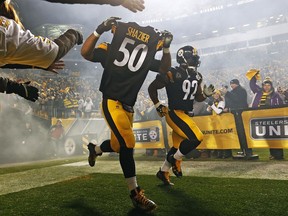 Pittsburgh Steelers defensive end Cameron Heyward (97) takes the field holding the jersey of teammate Ryan Shazier (50) during introductions before an NFL football game against the Baltimore Ravens in Pittsburgh, Sunday, Dec. 10, 2017.