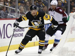 Pittsburgh Penguins' Sidney Crosby (87) works the puck behind the net with Colorado Avalanche's Erik Johnson (6) defending in the second period of an NHL hockey game in Pittsburgh, Monday, Dec. 11, 2017.