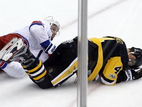 Pittsburgh Penguins' Justin Schultz (4) lies on the ice after a collision with New York Rangers' Rick Nash, left, during the first period of an NHL hockey game in Pittsburgh, Tuesday, Dec. 5, 2017. Schultz left the game with a lower body injury and returned briefly in the second period and did not play in the third. The Rangers won 4-3.