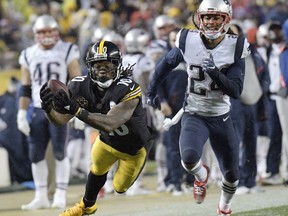 Pittsburgh Steelers wide receiver Martavis Bryant (10) dives to make a catch on a pass from quarterback Ben Roethlisberger with New England Patriots cornerback Stephon Gilmore (24) defending during the first half of an NFL football game in Pittsburgh, Sunday, Dec. 17, 2017.