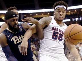 Duquesne's Jordan Robinson (55) and Pittsburgh's Jared Wilson-Frame tangle as they pursue the ball during the first half of an NCAA college basketball game, Friday, Dec. 1, 2017, in Pittsburgh.