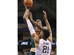Miami's Dewan Huell (20) shoots over Pittsburgh's Terrell Brown (21) during the first half of an NCAA college basketball game, Saturday, Dec. 30, 2017, in Pittsburgh.