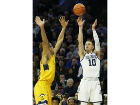 Villanova guard Donte DiVincenzo (10) takes a three point shot over La Salle center Miles Brookins (4) in the first half of an NCAA college basketball game, Sunday, Dec. 10, 2017, in Philadelphia.