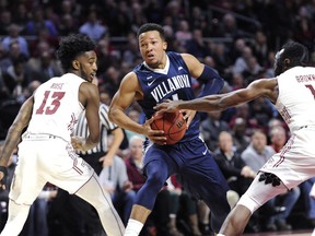 Villanova's Jalen Brunson (1) drives to the basket against Temple's Quinton Rose (13) and Josh Brown (1) during the first half an NCAA college basketball game, Wednesday, Dec. 13, 2017, in Philadelphia.