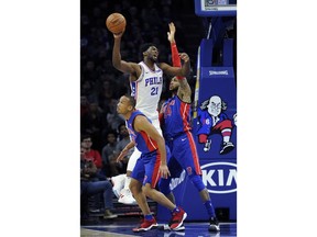 Philadelphia 76ers' Joel Embiid (21) drives to the basket as Detroit Pistons' Eric Moreland (24) and Avery Bradley (22) defend during the first half of an NBA basketball game, Friday, Dec. 2, 2017, in Philadelphia.