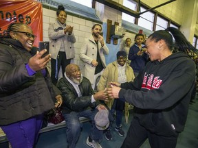 In this Wednesday, Dec. 20, 2017 photo, Dawn Staley, right, is greeted by neighborhood friends as Dawn Staley Day is celebrated at the Hank Gathers Recreation Center in Philadelphia.