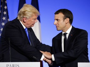 FILE - In this July 13, 2017 file photo, U.S President Donald Trump, left, shakes hands with French President Emmanuel Macron after a press conference at the Elysee Palace in Paris. Macron announced a competition for the grants hours after Trump declared he would withdraw the U.S. from the global accord reached in Paris in 2015 to reduce climate-damaging emissions. Macron is unveiling the winners Monday Dec.11, 2017 evening ahead of a climate summit.