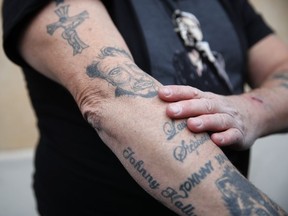 Johnny Hallyday's fan Yves Buisson shows his tattoos outside Hallyday's house in Marnes-la-Coquette, outside Paris, Wednesday, Dec.6, 2017. Johnny Hallyday, France's biggest rock star for more than half a century and an icon who packed sports stadiums and all but lit up the Eiffel Tower with his pumping pelvis and high-voltage tunes, has died. He was 74.