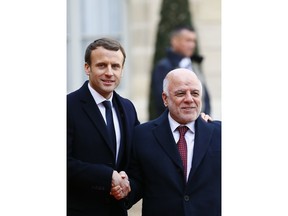 Iraq Prime Minister Haider al-Abadi is welcomed by French President Emmanuel Macron, left, before a lunch at the Elysee Palace in Paris, Tuesday, Dec. 12, 2017. More than 50 world leaders are gathering in Paris for a summit that Macron hopes will give new momentum to the fight against global warming, despite U.S. President Donald Trump's rejection of the Paris climate accord.