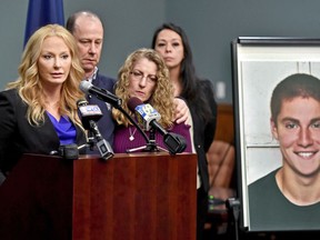 FILE – In this May 5, 2017, file photo, Centre County, Pa., District Attorney Stacy Parks Miller, left, announces findings an investigation into the death of Penn State University fraternity pledge Tim Piazza, seen in photo at right, as his parents, Jim and Evelyn Piazza, second and third from left, stand nearby during a news conference in Bellefonte, Pa. Parks is scheduled to release grand jury recommendations Friday, Dec. 15, 2017, on the fraternity culture at Penn State.