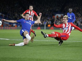 Atletico's Antoine Griezmann, right, shoots on goal during the Champions League Group C soccer match between Chelsea and Atletico Madrid at Stamford Bridge stadium in London Tuesday, Dec. 5, 2017.