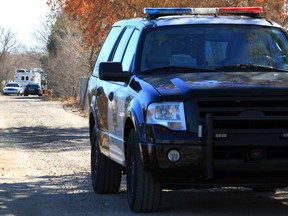 FILE - In this Jan. 20, 2013 file photo, a Bernalillo County sheriff's deputy blocks the dirt road that leads to a home where detectives were investigating the deaths of five people who were shot to death south of Albuquerque, N.M. The ACLU filed a lawsuit Tuesday, Dec. 5, 2017, in New Mexico state district court on behalf of Sherese Crawford, 38, against the Bernalillo County Sheriff's Department stemming from three traffic stops that the ACLU said amounted to racial profiling.