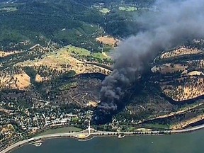 FILE- In this June 3, 2016, file image, from video provided by KGW-TV, smoke billows from a Union Pacific train that derailed near Mosier, Ore., in the scenic Columbia River Gorge. The Trump administration is angering environmental groups and residents of the Columbia River Gorge by rolling back a 2015 rule on oil train safety. (KGW-TV via AP, File)